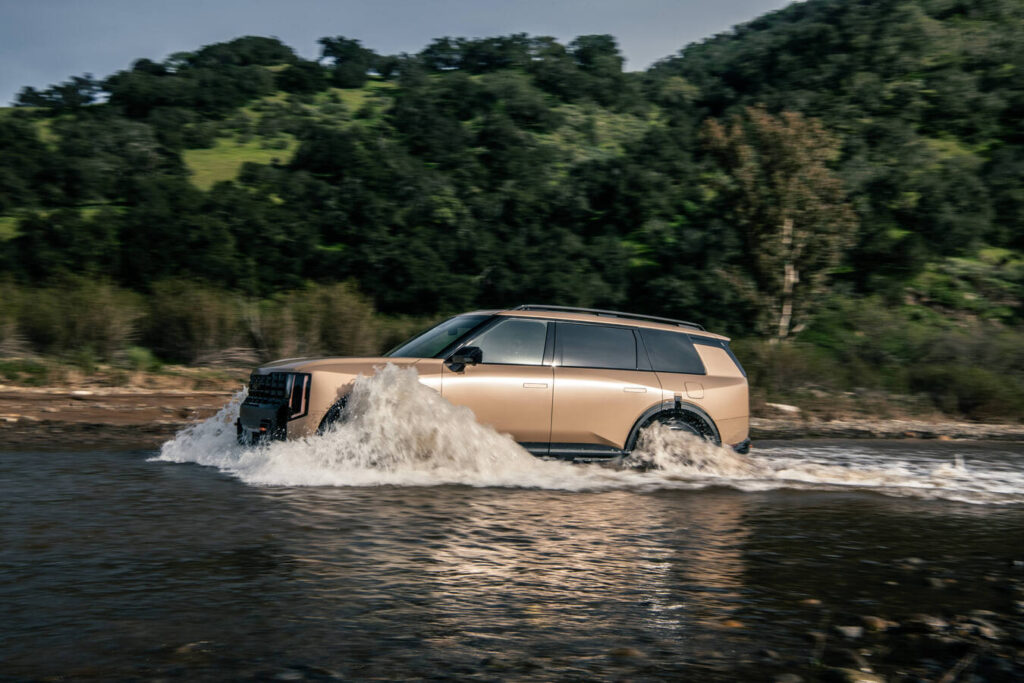 2027 Kia Telluride in tan crossing a river in profile