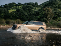 2027 Kia Telluride in tan crossing a river in profile