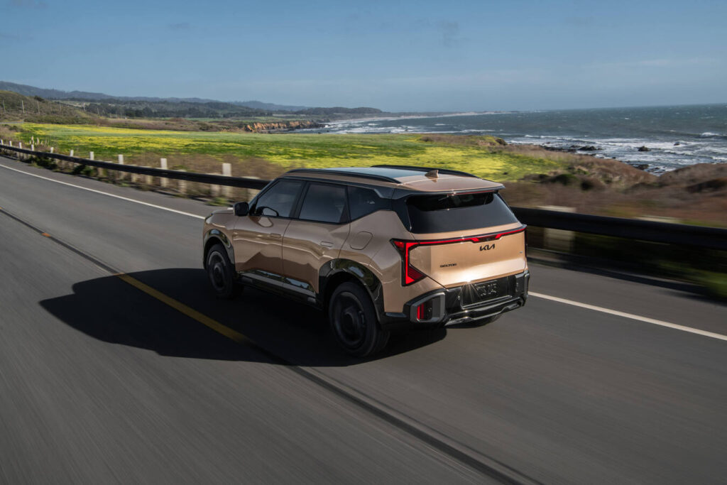 2027 Kia Seltos X-Line in bronze from the rear on a coastal highway