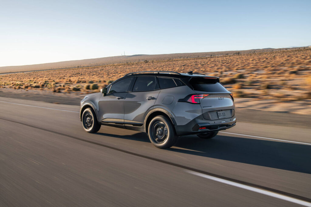 2027 Kia Sportage in gray from the rear on a desert highway