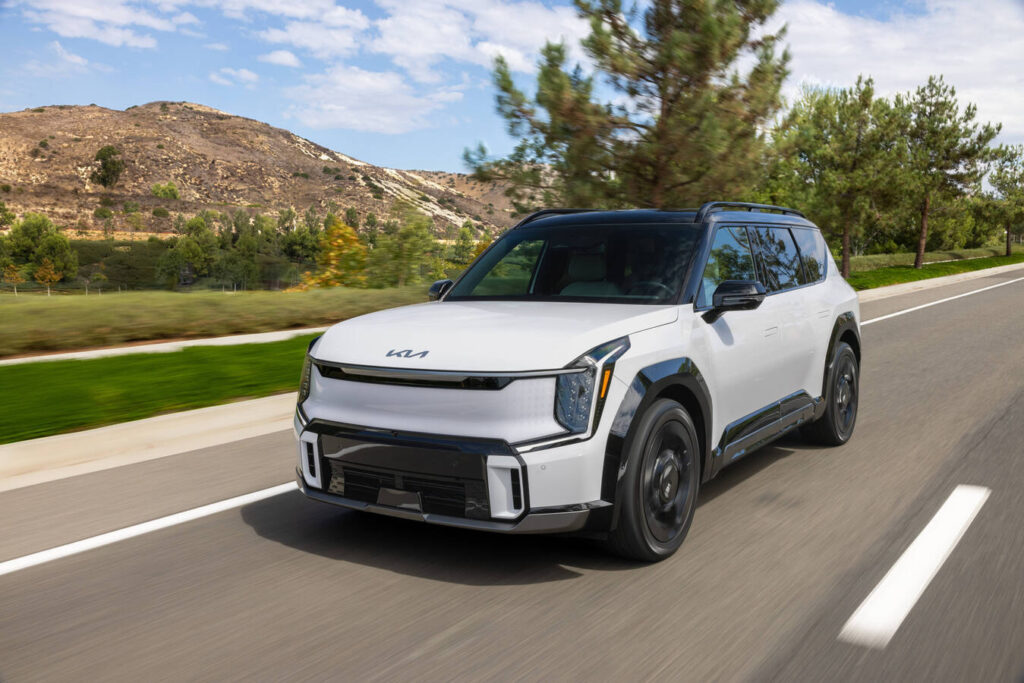 2027 Kia EV9 driving past rolling hills