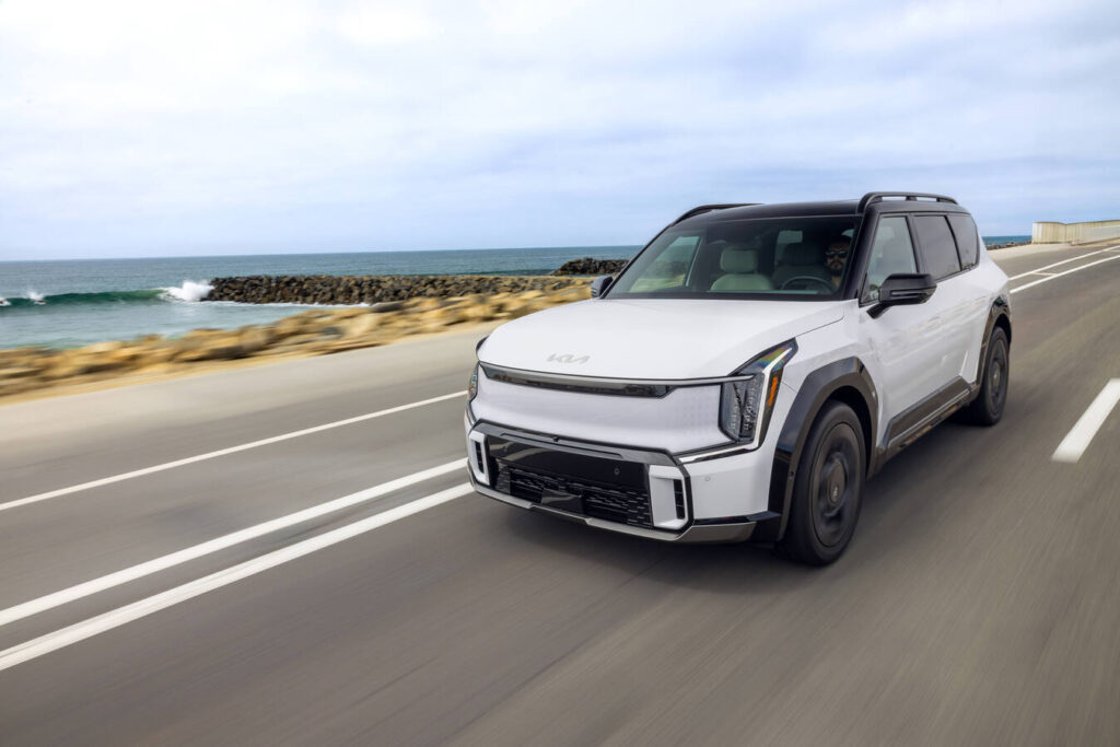2027 Kia EV9 driving along a coastal road