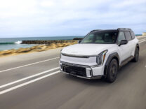 2027 Kia EV9 driving along a coastal road