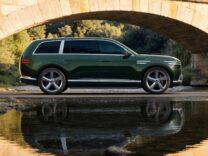 2028 Genesis GV90 in green parked beneath a stone bridge